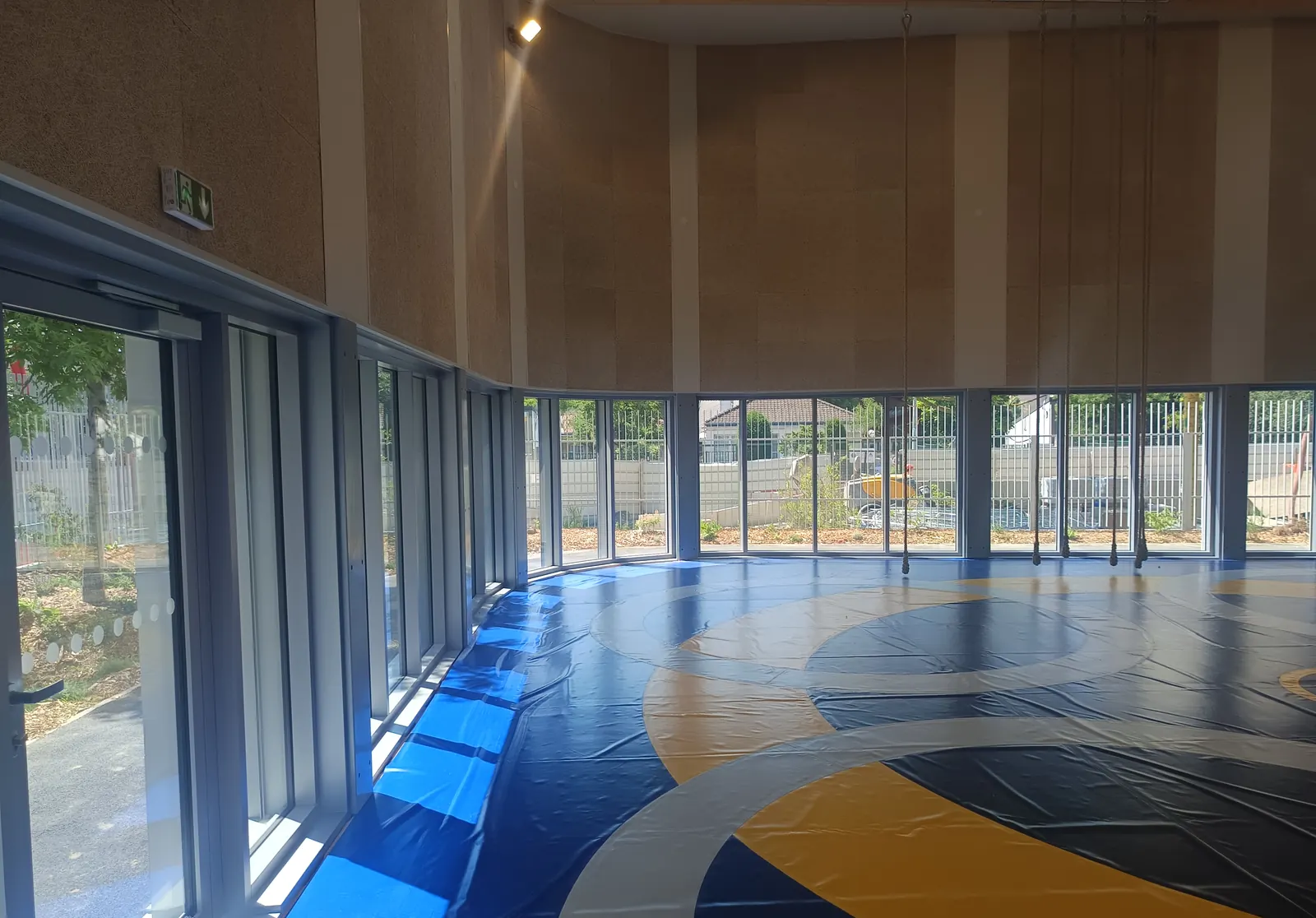 Salle de sports de contact de l’équipement des Malassis à Bagnolet, tapis de lutte et façade vitrée